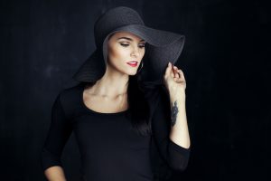 Beautiful brunette woman looking away, wearing a hat.